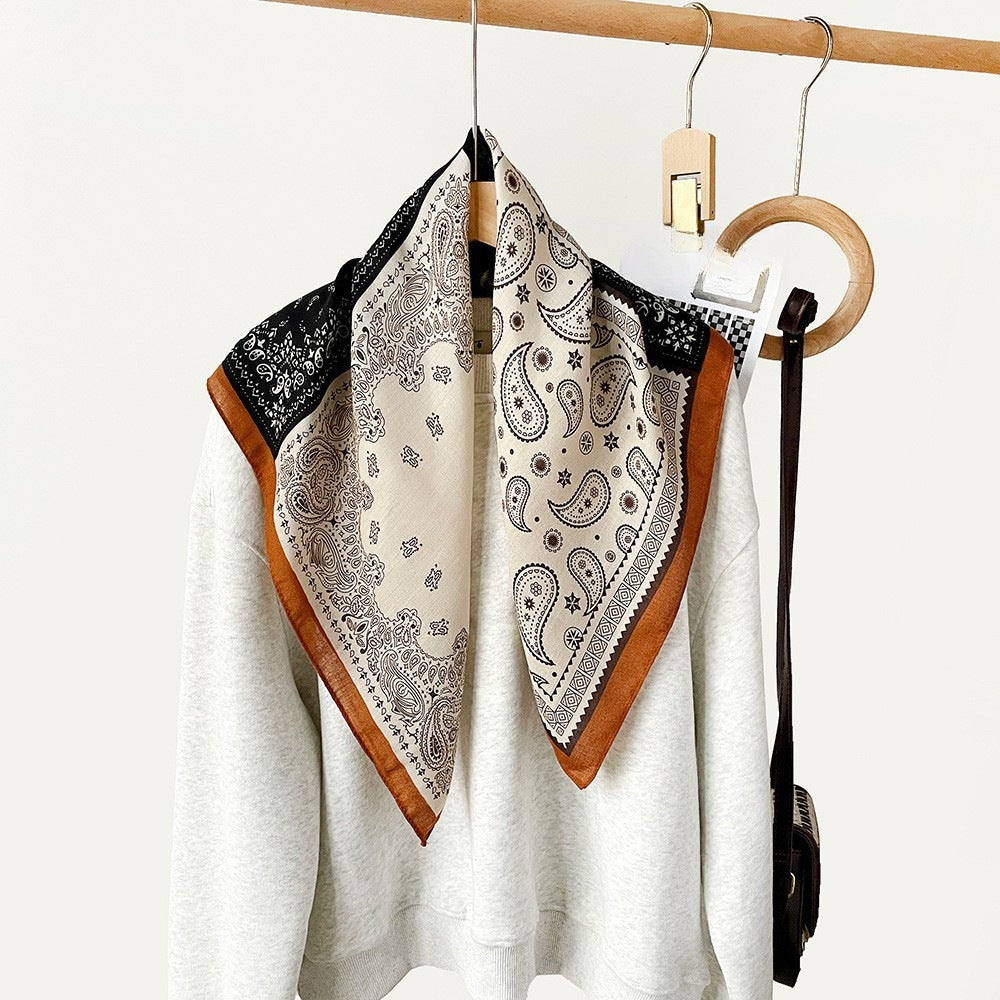 Black and cream paisley bandana scarf tied as a neckerchief
