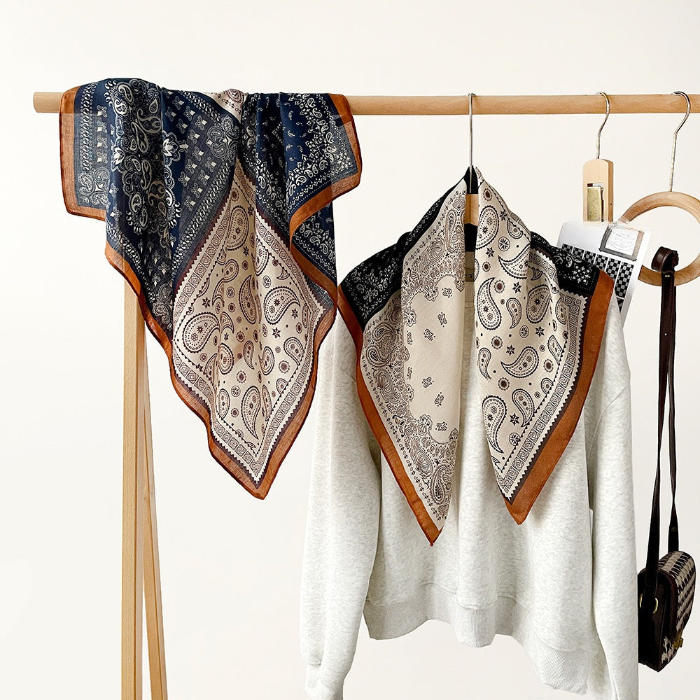 Paisley patchwork square scarves in navy and black on a rack