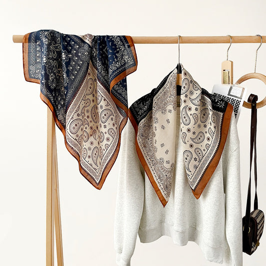 Paisley patchwork square scarves in navy and black on a rack