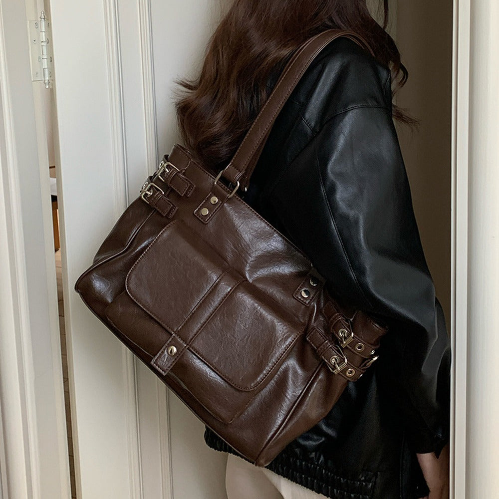 Woman carrying the coffee brown faux leather tote on her shoulder