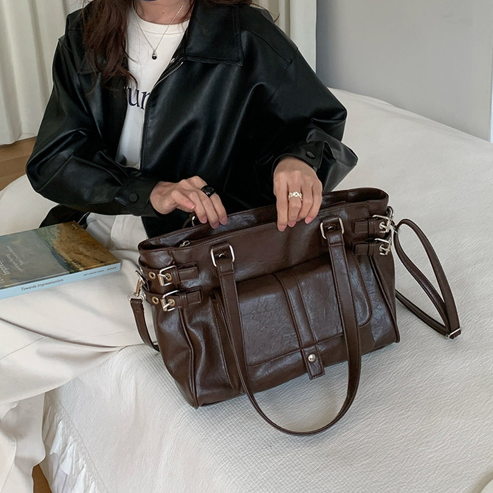 Opening the zip top of the large tote, with the detachable crossbody strap