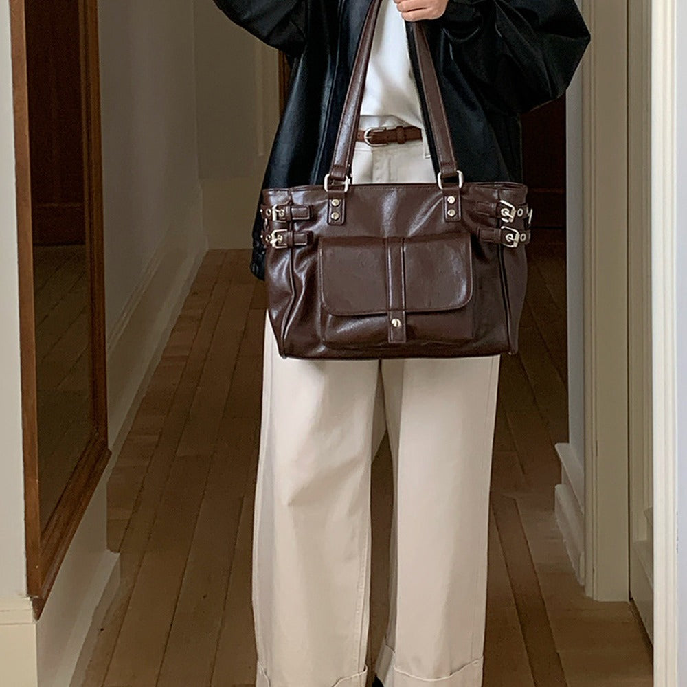 Full-length look carrying the tote by its long shoulder straps