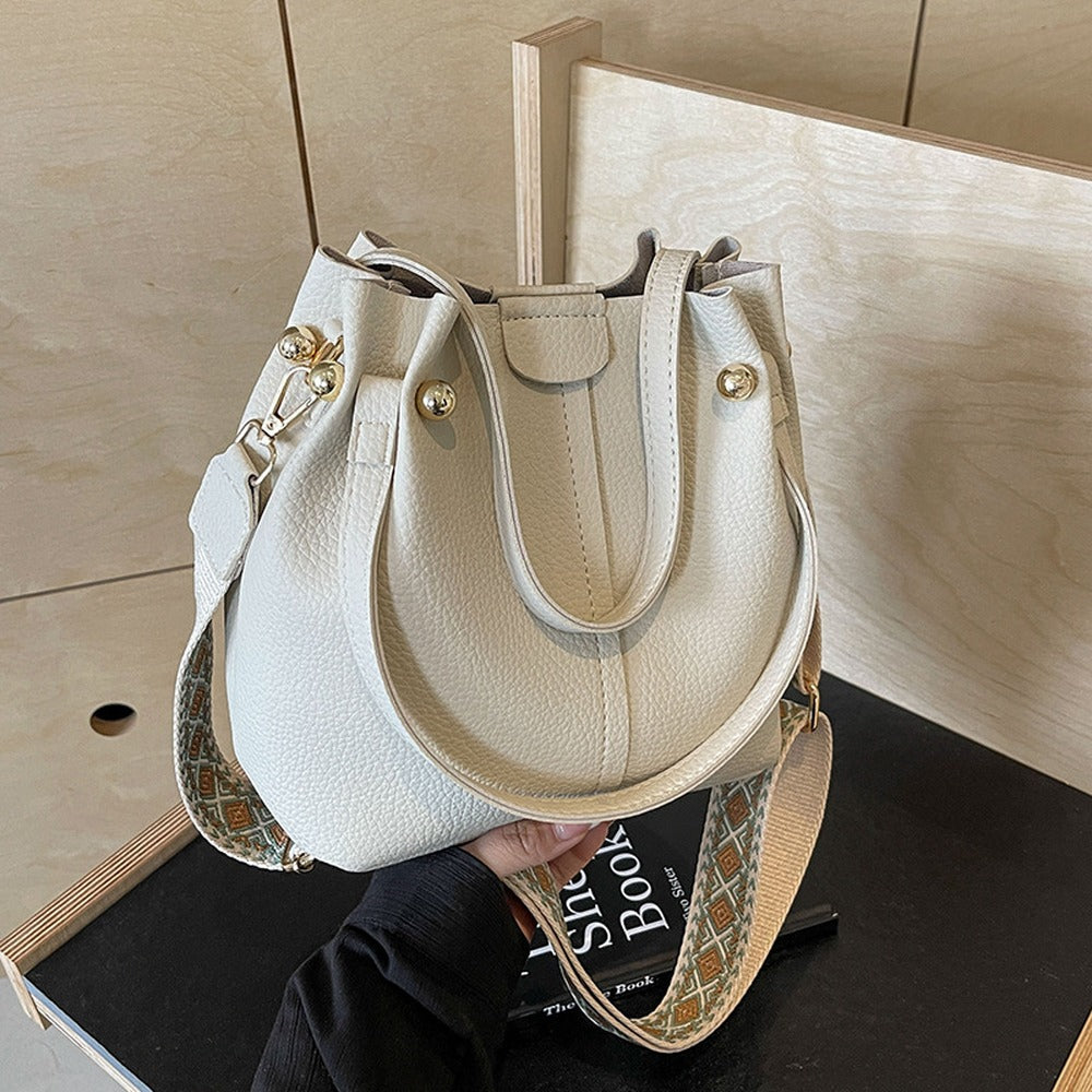 Cream bucket bag with top handles and wide crossbody strap